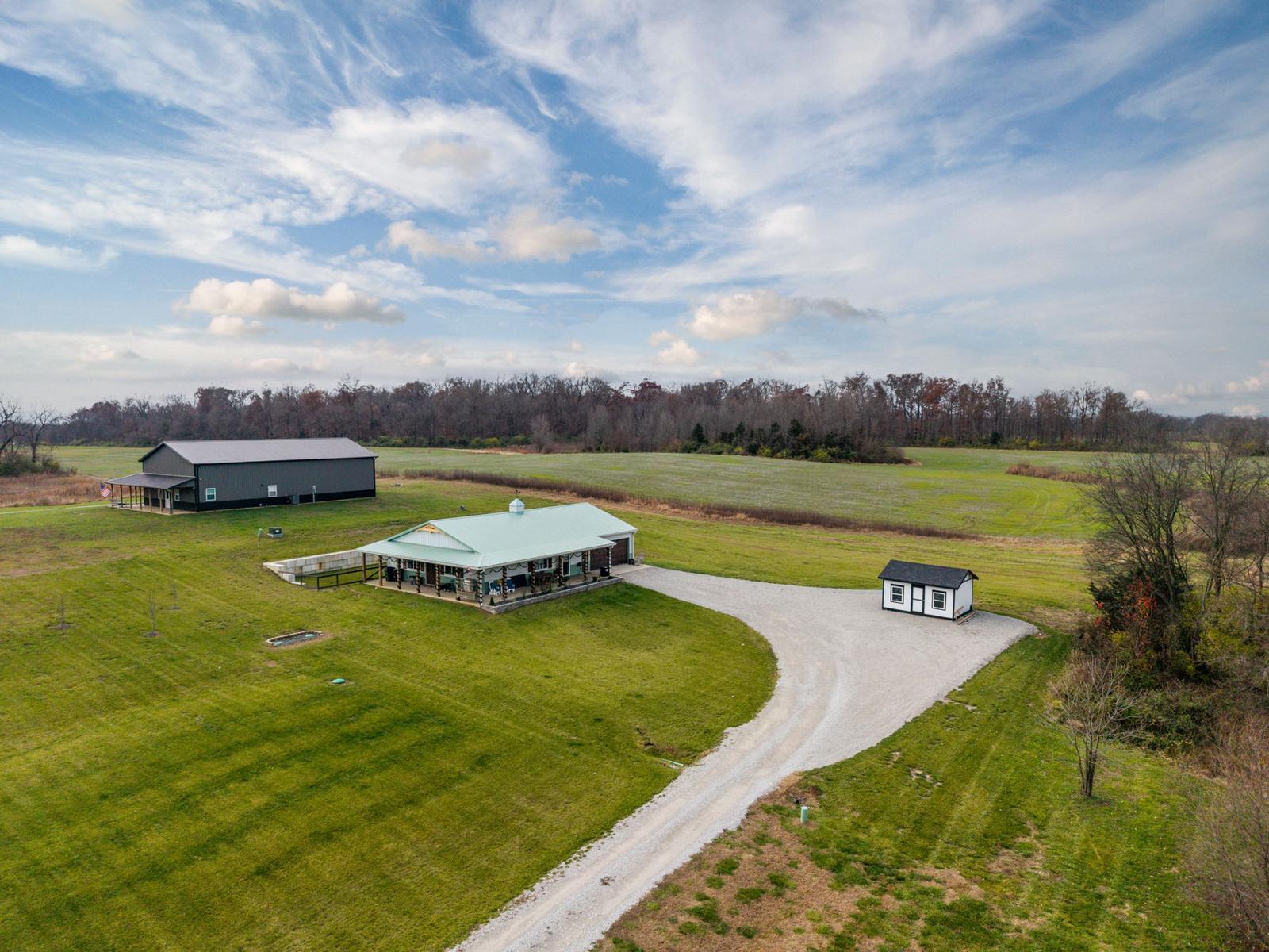 Open acreage with a long gravel drive